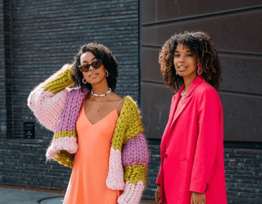 Two people in colourful outfits on a street